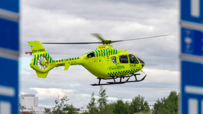 FinnHEMS neongula helikopter flyger.