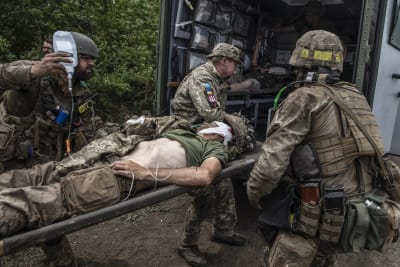 En skadad ukrainsk soldat lyfts in i en ambulans vid fronten.