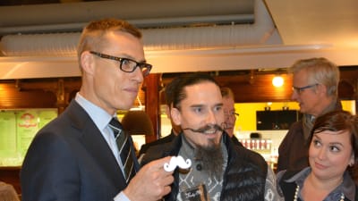 Alexander Stubb och Juhana Helmenkalastaja med ett reflex för att samla in pengar till Movember, Åbo Saluhall, 4.11.2014