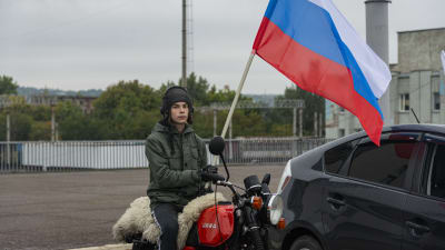  En pojke på motorcykel håller upp en rysk flagga under ett motorcykelrally till stöd för en folkomröstning om att gå med i Ryska federationen i Luhansk, Ukraina, 23 september 2022.   