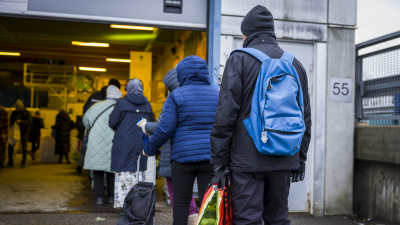 Människor som står i brödkön i Kvarnbäcken i Helsingfors.