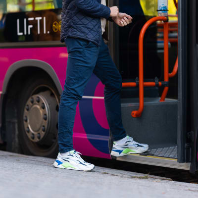Nuori mies astuu linja-autoon.