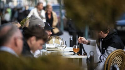 Personer sitter på en uteservering.