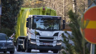 En sopbil kör på en parkering.