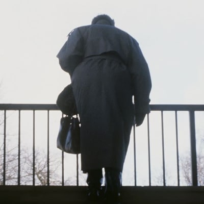 En äldre dam går uppför trappan