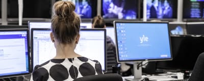 En kvinna arbetar vid datorn på Yle Uutisets nyhetsredaktion.
