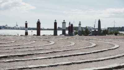 Miniatyrfyrar i havsmiljö, i förgrunden en labyrint gjord av sand och sten.