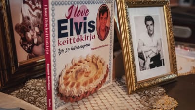 Kokbok med text (på finska): "Elvis-kokbok" och bild på tårta.