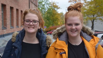 Två studerande tittar in i kameran.