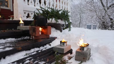 Fyra tända marschaller på en trappa. En marschall värmer en kaffepanna, som står på två tegelstenar.