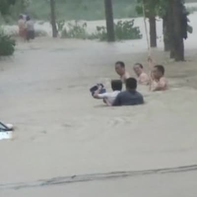 Ihmisiä tulvivalla tiellä.