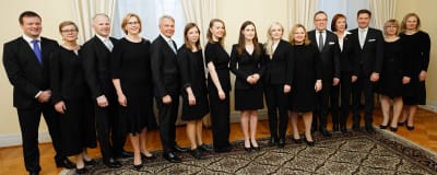 Finlands regering står på rad för att fotograferas i Statsrådsborgen, alla är klädda i svart.