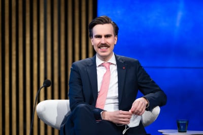 Matias Mäkynen, SDP, sitter leende framför en mikrofon.