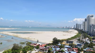 Sand invid havet i Georgetown i Malaysia. Sand har dumpats i havet för att göra stadens areal större.