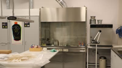 Ett laboratorium med en bår och ett kemikalieskåp.