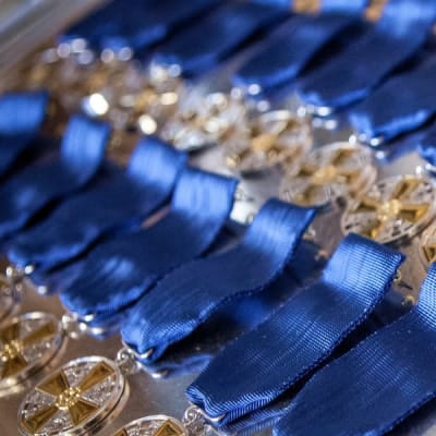 Massor av glittrande medaljer i flera rader med blå medaljband