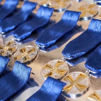 Massor av glittrande medaljer i flera rader med blå medaljband