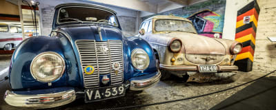 Två östtyska veteranbilar: En glänsande blå IFA bredvid en smutsig och rostig Trabant