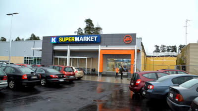 Bilar på en regnvåt parkeringsplats.