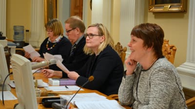 Kristina Saari (SFP), Jarmo Ittonen (Vf) och stadssekreterare Milla Kallioinen mitt i rösträkningen. Fullmäktiges ordförande Carola Sundqvist (SFP) i förgrunden.