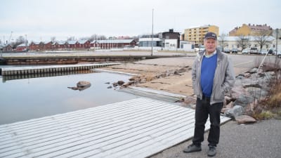 Kalle Niemi står vid gästhamnsbryggan i Hangös Östra hamn. I bakgrunden syns HSF och de röda magasinen.