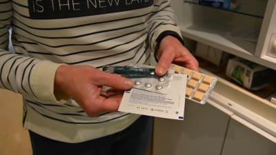 Händer som håller i olika slags tabletter.