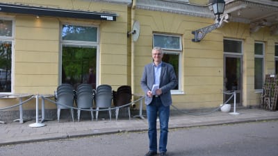 Tony Jäntti står vid Bassihuset i Åbo. Balkong och utemöbler bakom honom