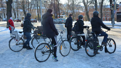 Ett gäng cyklister står vid trafikljuset i centrala Åbo.