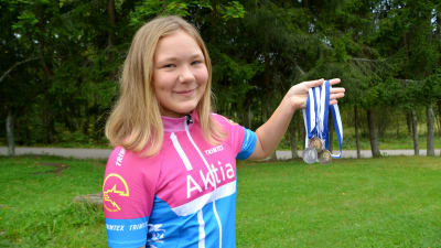 Sandra Jensen håller upp FM-medaljerna hon fått under sommaren 2016.