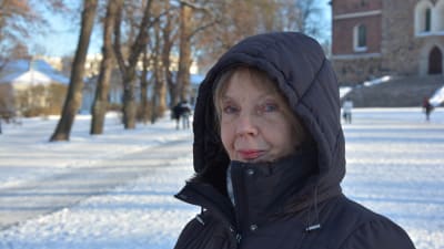 Merja Marjamäki tittar in i kameran vid Domkyrkan i Åbo.