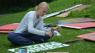 Nina Sirén målar skyltar till Faces 2015.
