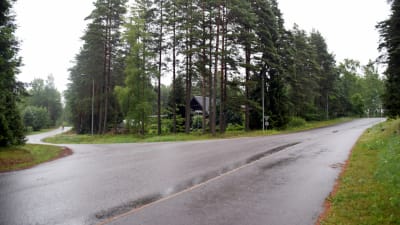 Ett foto på en korsning där asfalten är våt av regn. 
