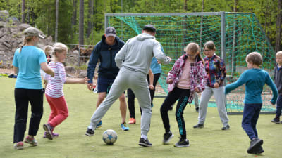 Richard och Fredrik Jensen spelar fotboll med Vårberga skolas elever.