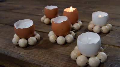 Ljushållare av äggskal och träkulor på ett bord.