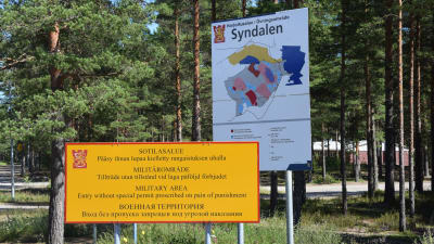 Två skyltar, den ena är karta över Syndalens övningsområde och den andra en skylt där det står - militärområde - tillträde utan tillstånd vid laga påföljd förbjuden.
