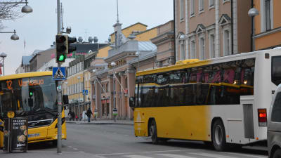 Två gula stadsbussar i centrum av Åbo.