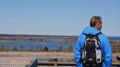 Turist blickar ut över Kvarkens världsnaturarv från utkikstornet saltkaret i Svedjehamn i Björkö.