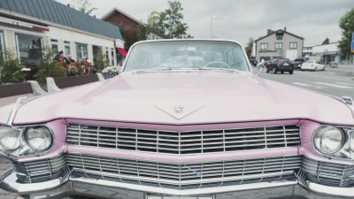 Dollargrinet på en rosa Cadillac.