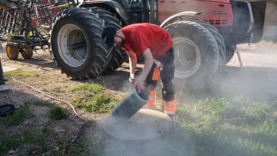 Kristoffer Nilsson putsar luftfiltret till sin traktor