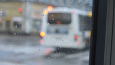 En buss syns suddigt genom ett fönster. 