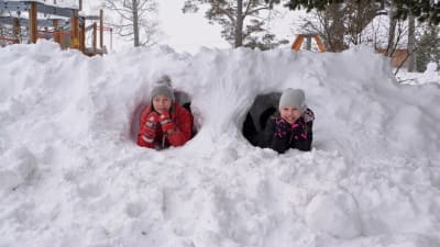Neela Nyman och Annica Aarnisalo tittar ut från varsin snötunnel.