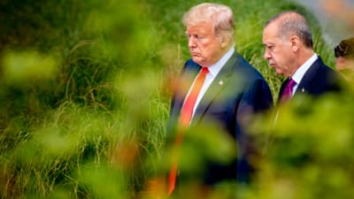 Donald Trump och Recep Tayyip Erdogan går sida vid sida i en lummig trädgård i Bryssel juli 2018. 
