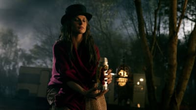 Rose the Hat (Rebecca Ferguson) sitter på marken med en behhållare av människogas i handen.