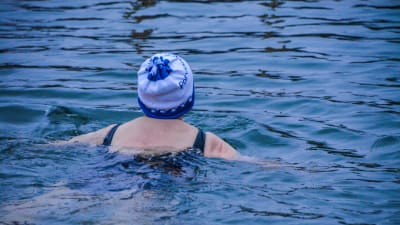 Kvinna med mössa på huvudet simmar