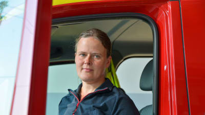 Johanna Nyholm vid en dörren till en brandbil. 