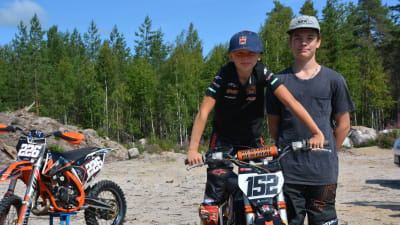 Två unga motocrossförarare står bredvid varandra.