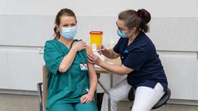 En sjukskötare vaccineras med coronavaccinet.
