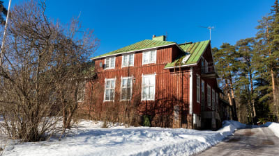 Gammal skolbyggnad med röda väggar.