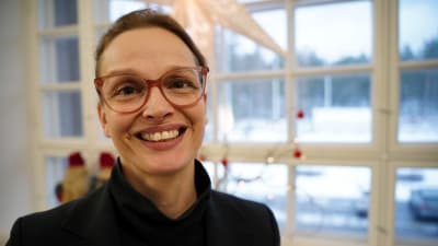 Raseborgs stadsdirektör Petra Theman leende framför ett fönster. 