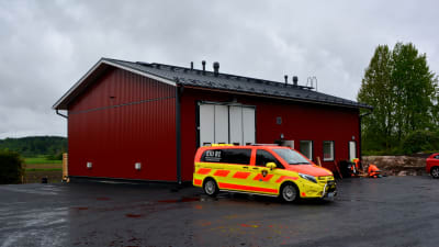 Ett rött hus med en ambulans utanför